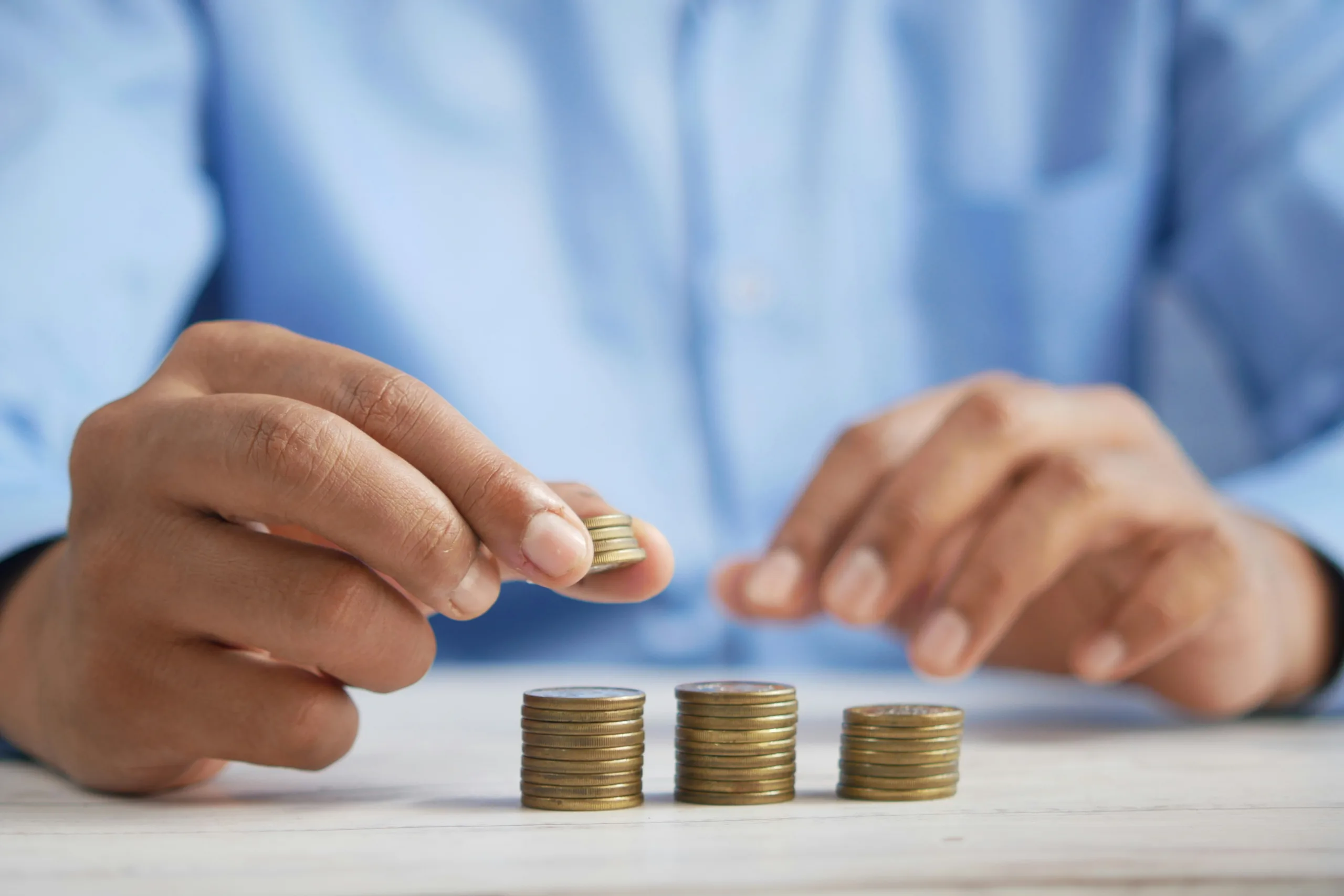 A person counting coins as part of budgeting finances.