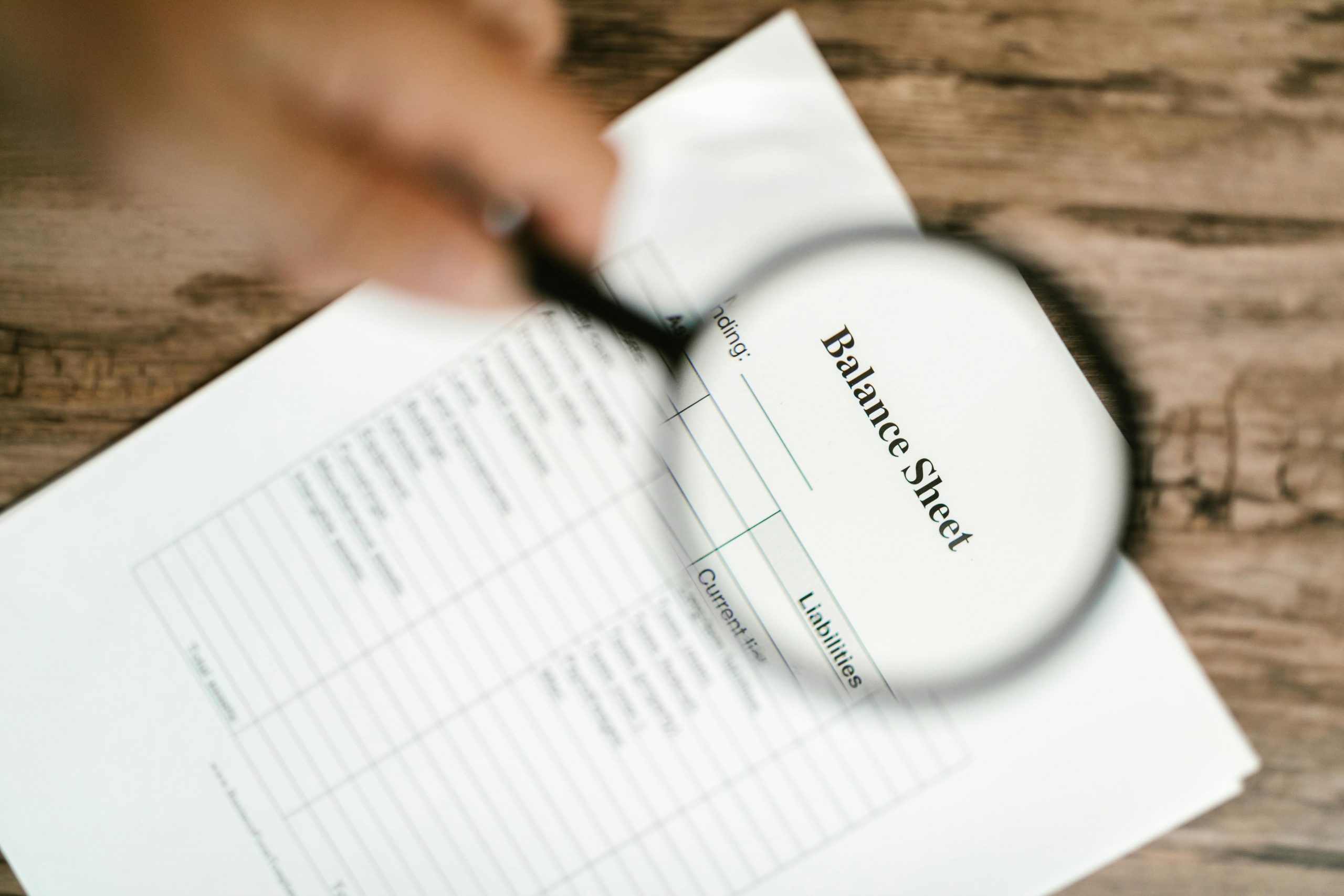 Magnifying glass hovering over financial documents